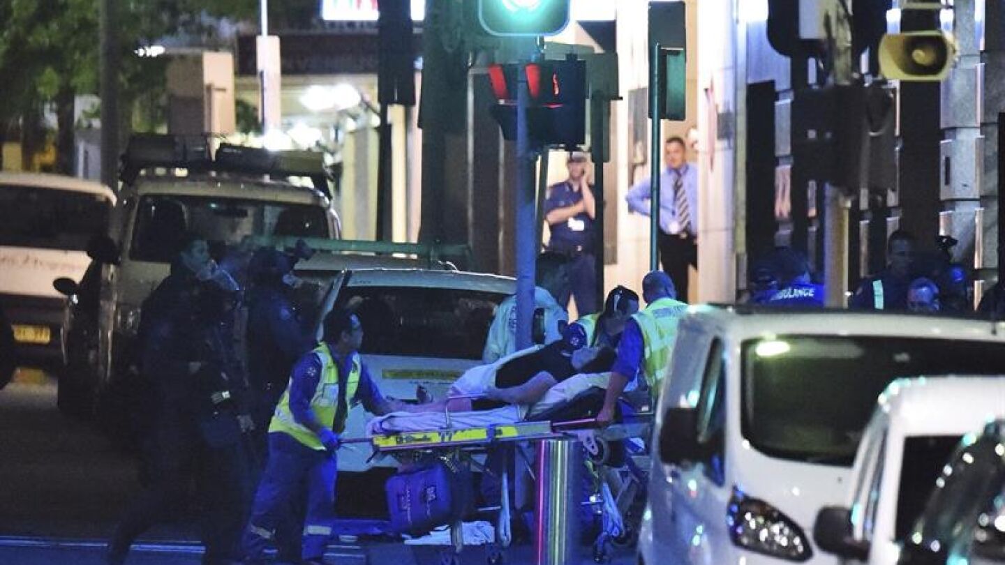 Los servicios m&eacute;dicos atienden a un herido junto a la cafeter&iacute;a de Sidney
