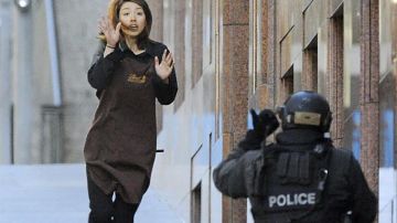 Una empleada abandona la cafetería que un hombre armado tiene tomada en Sidney