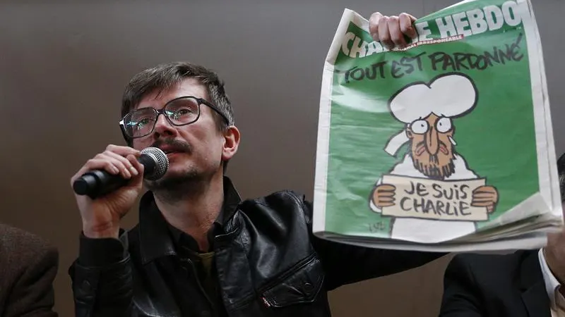 El caricaturista Luz sostiene la nueva portada de Charlie Hebdo