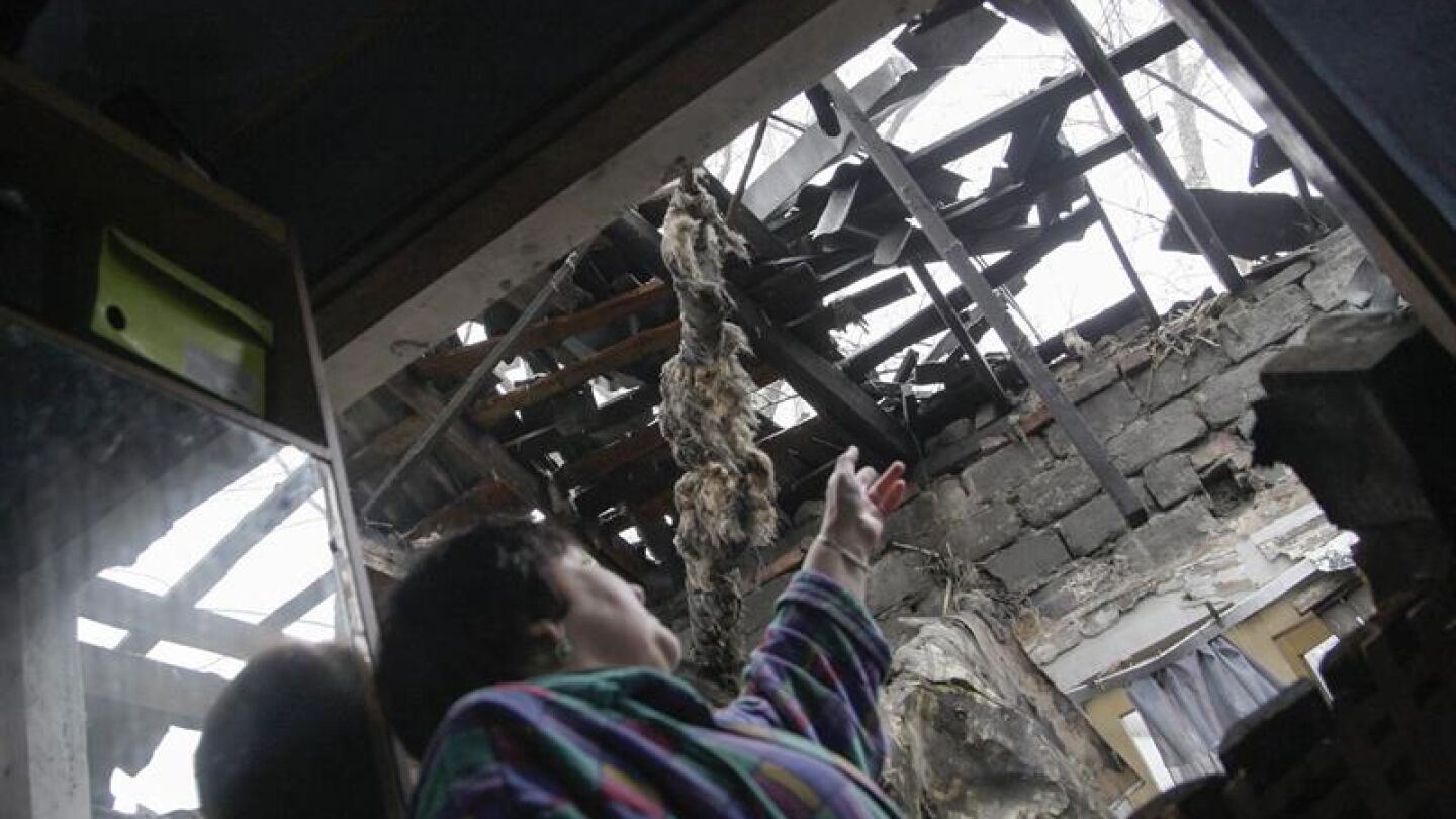 Una mujer se&ntilde;ala los desperfectos causados en su casa por los bombardeos en Donetsk. Imagen de archivo. 