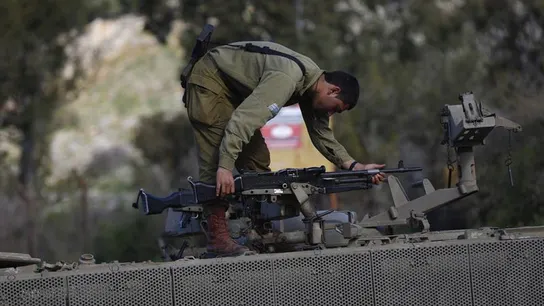 Soldados israelíes colocan una ametralladora sobre su vehículo Soldados israelíes colocan una ametralladora sobre su vehículo