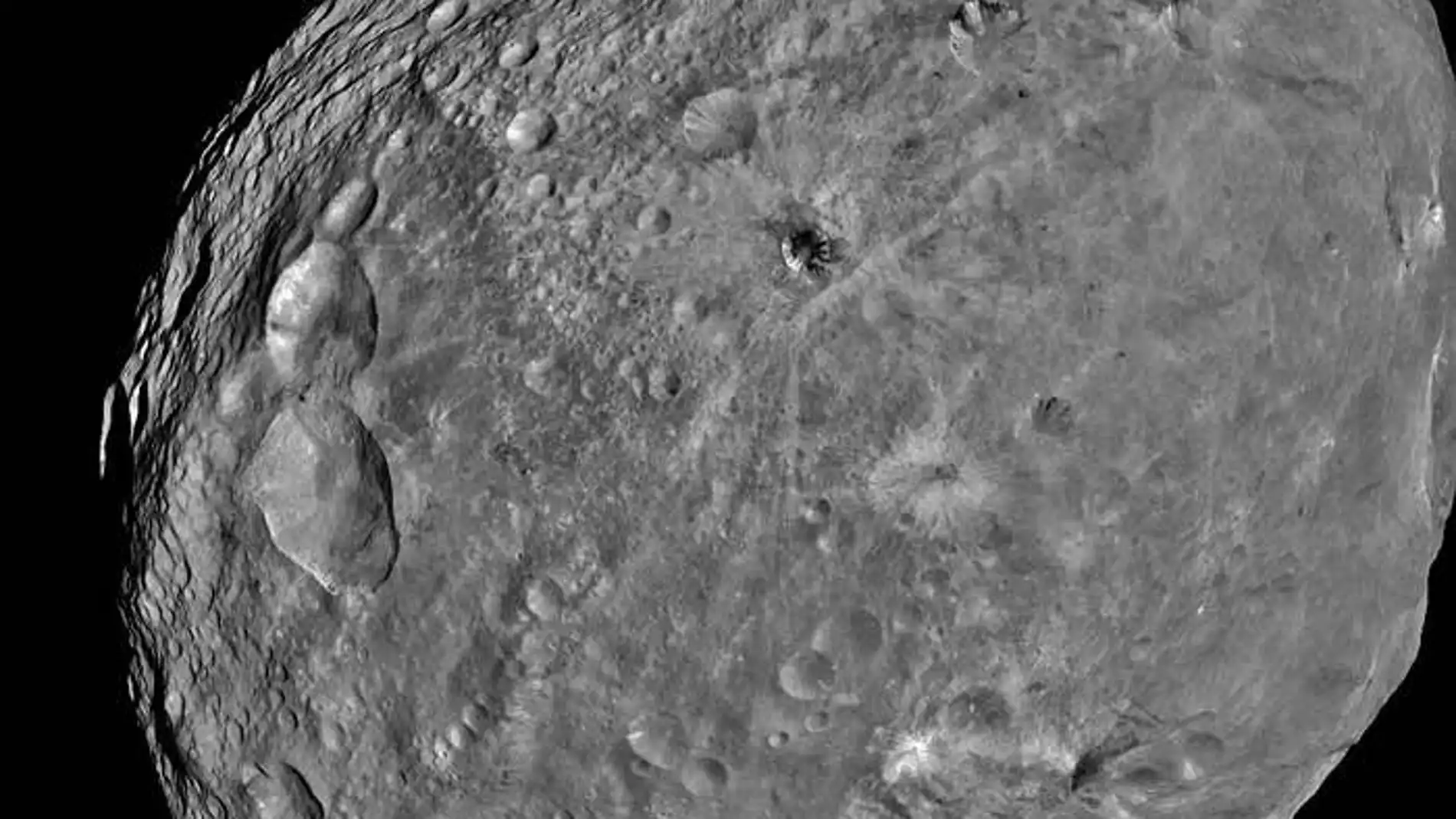Cráter Cornelia en Vesta. A la derecha se ven los barrancos con los bordes curvados y el depósito con forma de abanico