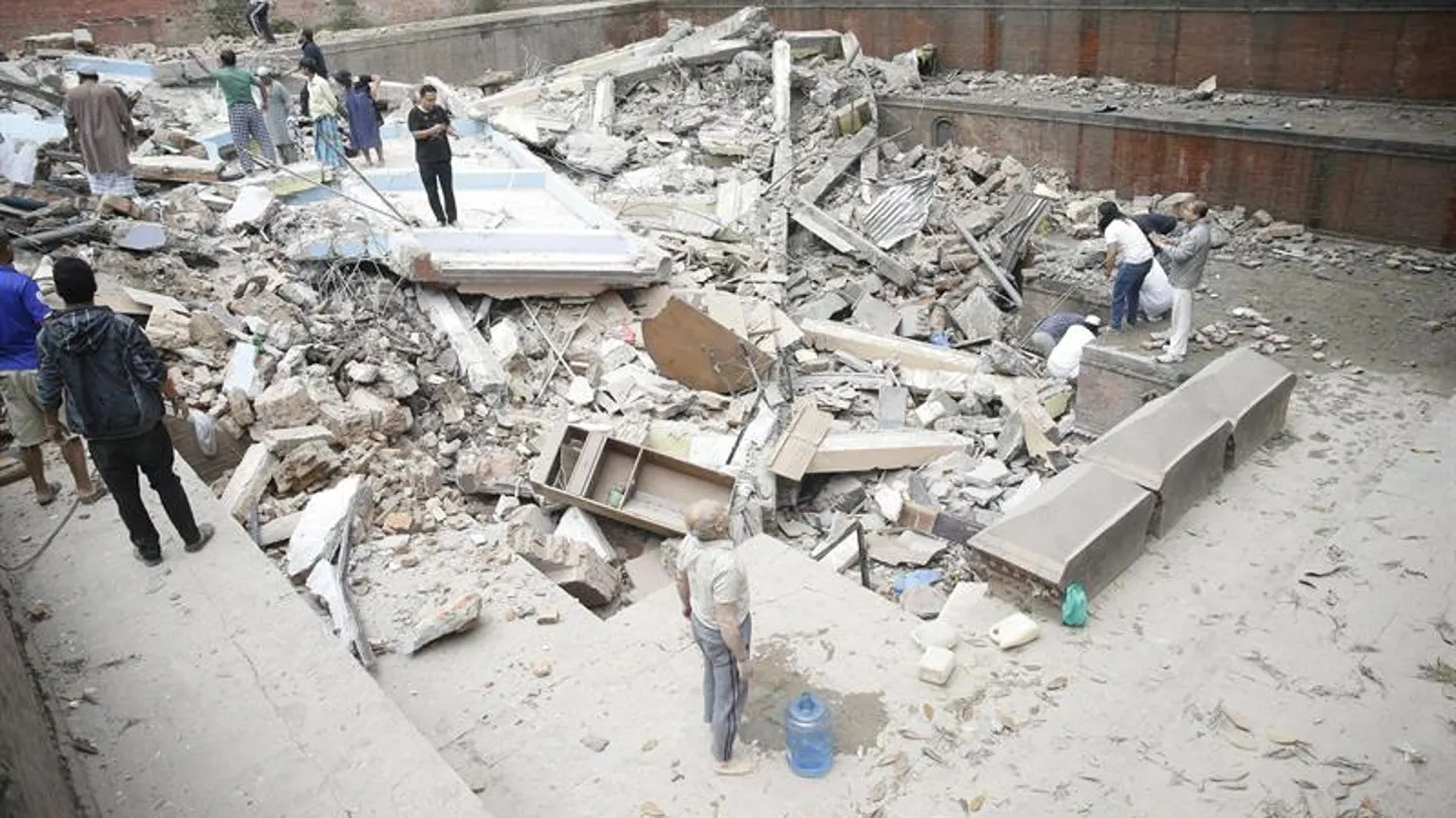 Personas caminando sobre las ruinas de un edificio caído durante el terremoto Personas caminando sobre las ruinas de un edificio caído durante el terremoto