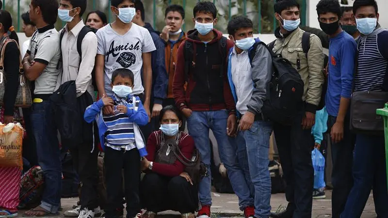 Una multitud hace cola para coger un autobús fletado por el Gobierno nepalí