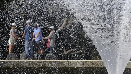 Turistas tras una fuente Turistas tras una fuente