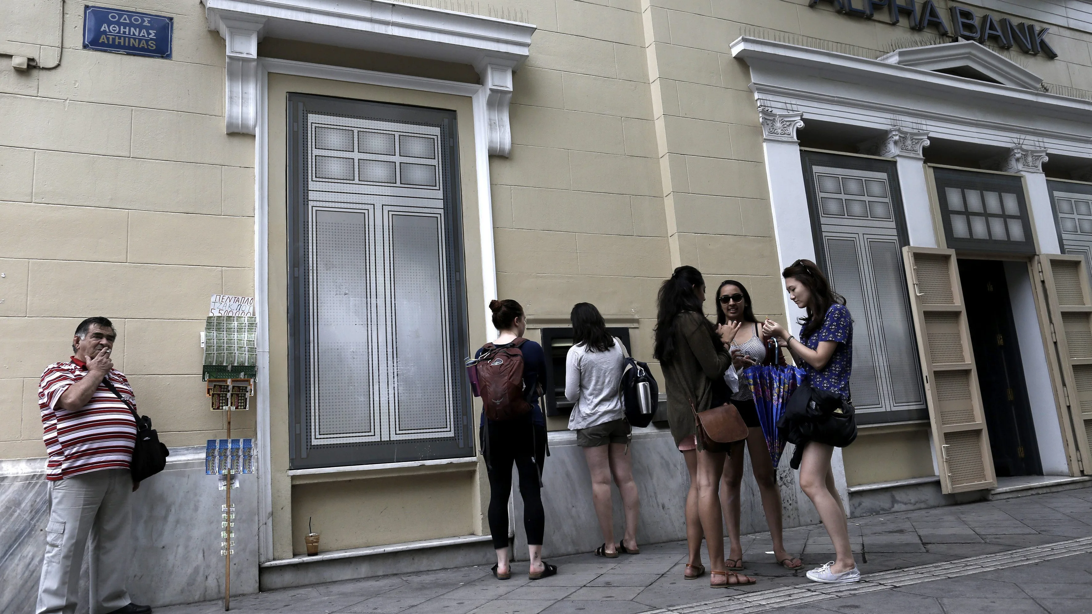 Turistas haciendo cola para sacar dinero de un cajero en Atenas Turistas haciendo cola para sacar dinero de un cajero en Atenas