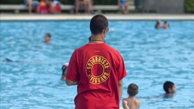 Socorrista vigilando una piscina.