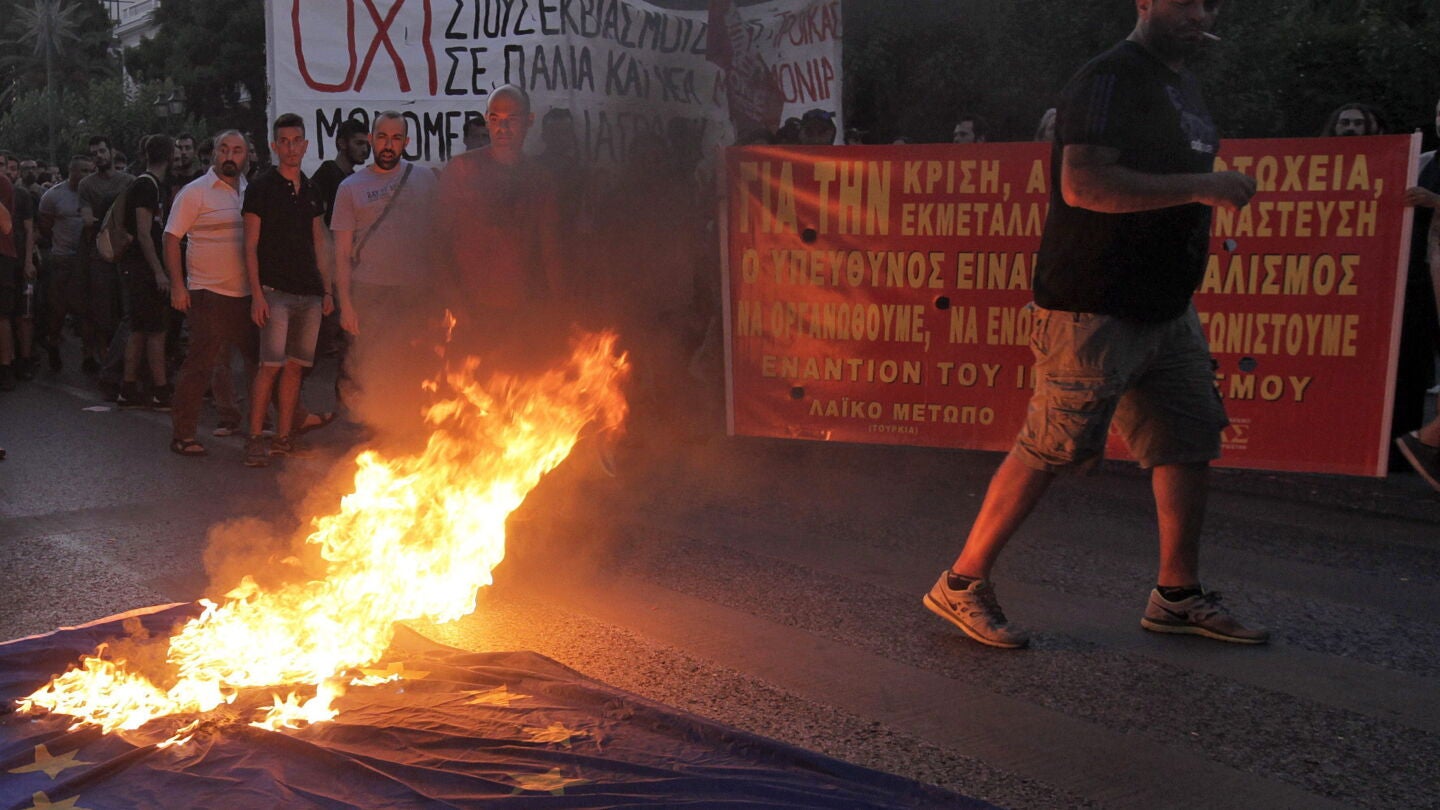 Simpatizantes del partido de izquierda extraparlamentaria Frente de Izquierda Anticapitalista queman una bandera de la Uni&oacute;n Europea