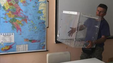 Un operario coloca una urna electoral en Atenas, Grecia.
