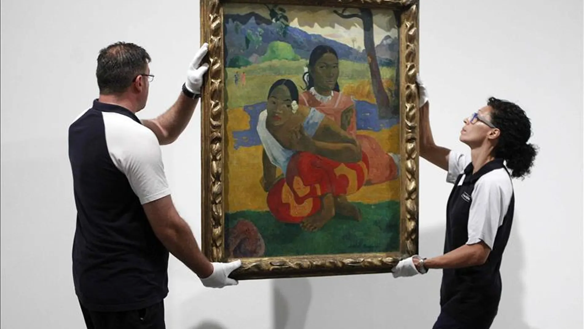 Dos operarios cuelgan el cuadro de Paul Gauguin "Nafea faa ipoipo"
