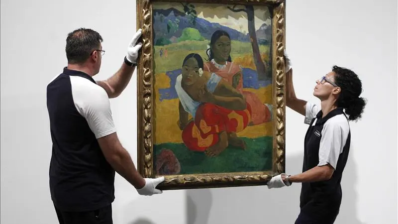 Dos operarios cuelgan el cuadro de Paul Gauguin "Nafea faa ipoipo"