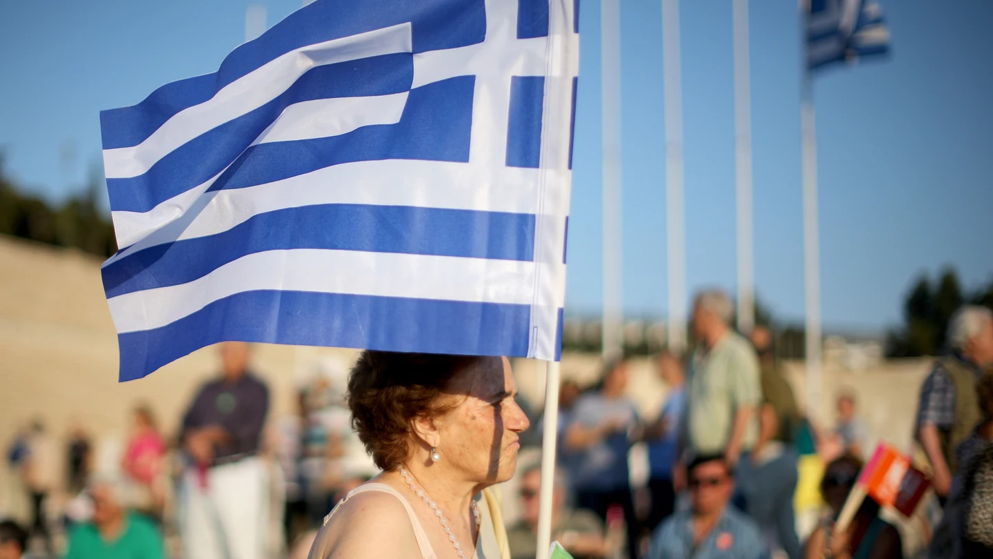 Una mujer porta una bandera de Grecia Una mujer porta una bandera de Grecia