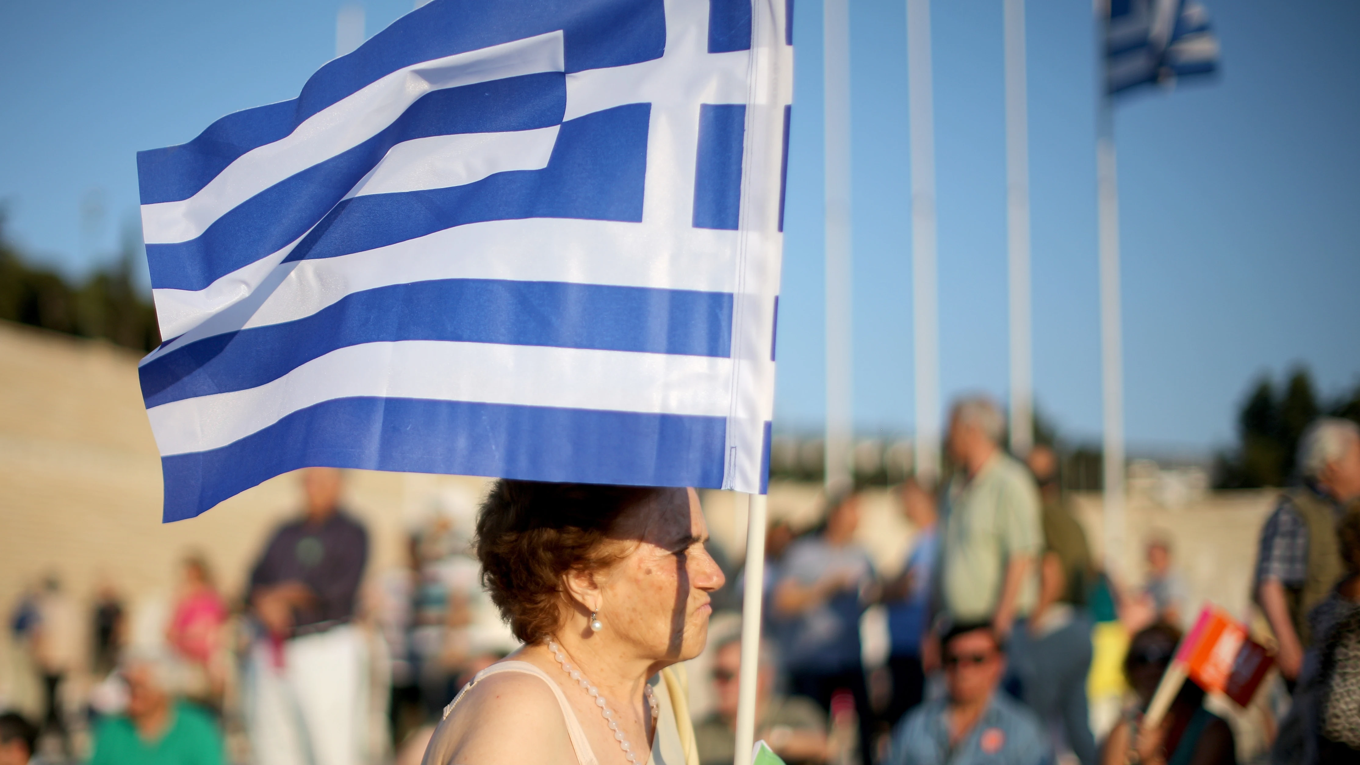 Una mujer porta una bandera de Grecia