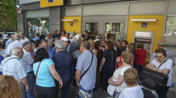 Pensionistas hacen cola para retirar dinero a la entrada de una sucursal bancaria en Salónica, Grecia.