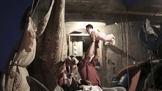 Una familia descansa en su casa destruida por el conflicto Israel-Gaza en 2014 Una familia descansa en su casa destruida por el conflicto Israel-Gaza en 2014