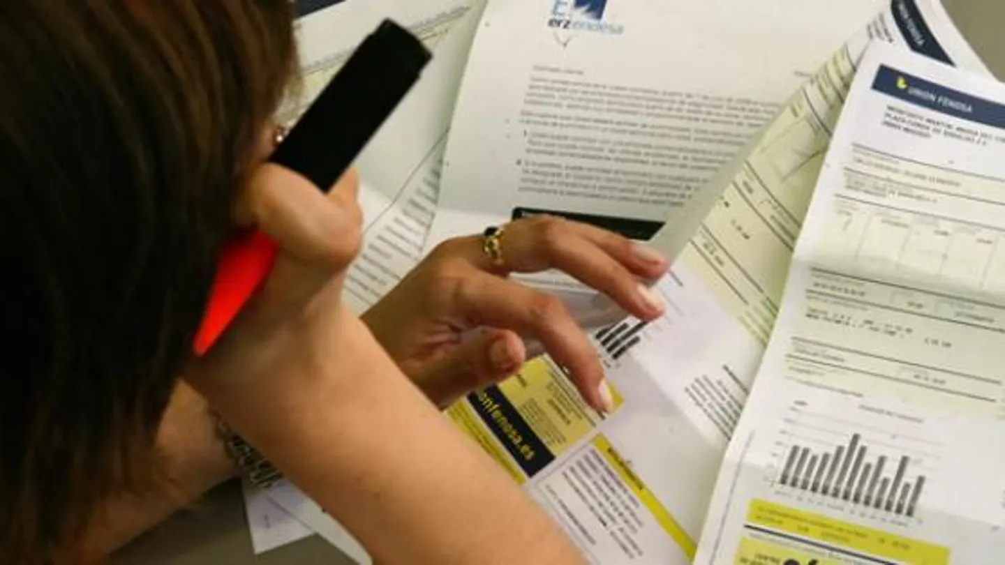 Una mujer estudia su factura de la luz Una mujer estudia su factura de la luz