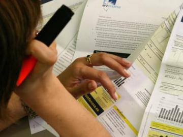 Una mujer estudia su factura de la luz Una mujer estudia su factura de la luz