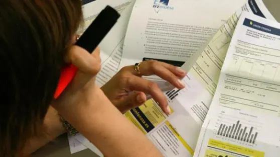Una mujer estudia su factura de la luz Una mujer estudia su factura de la luz