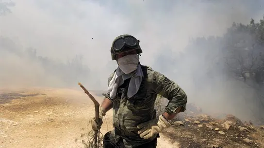 Un soldado intenta extinguir las llamas en Atenas Un soldado intenta extinguir las llamas en Atenas