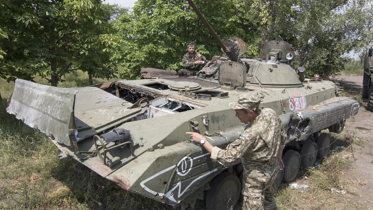 Voluntarios del ejército ucraniano examinando un tanque que perteneció a los prorrusos Voluntarios del ejército ucraniano examinando un tanque que perteneció a los prorrusos