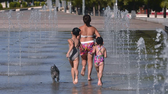 Una familia se refresca en una fuente Una familia se refresca en una fuente