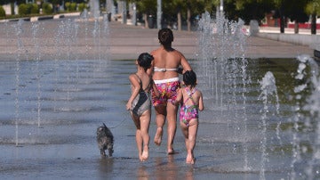 Una familia se refresca en una fuente