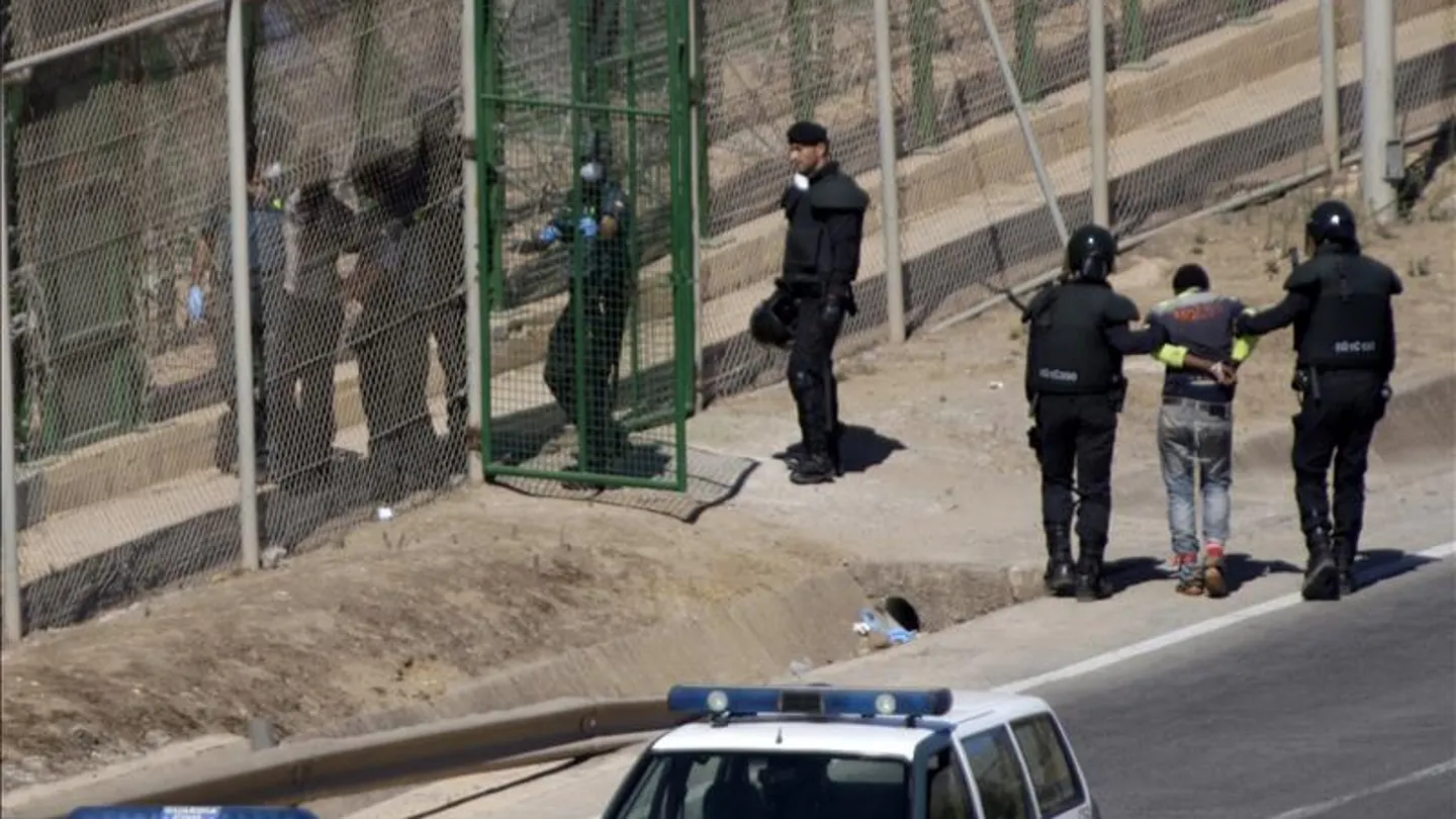 Dos inmigrantes en la valla de Melilla entregados a Marruecos en agosto de 2014 Dos inmigrantes en la valla de Melilla entregados a Marruecos en agosto de 2014