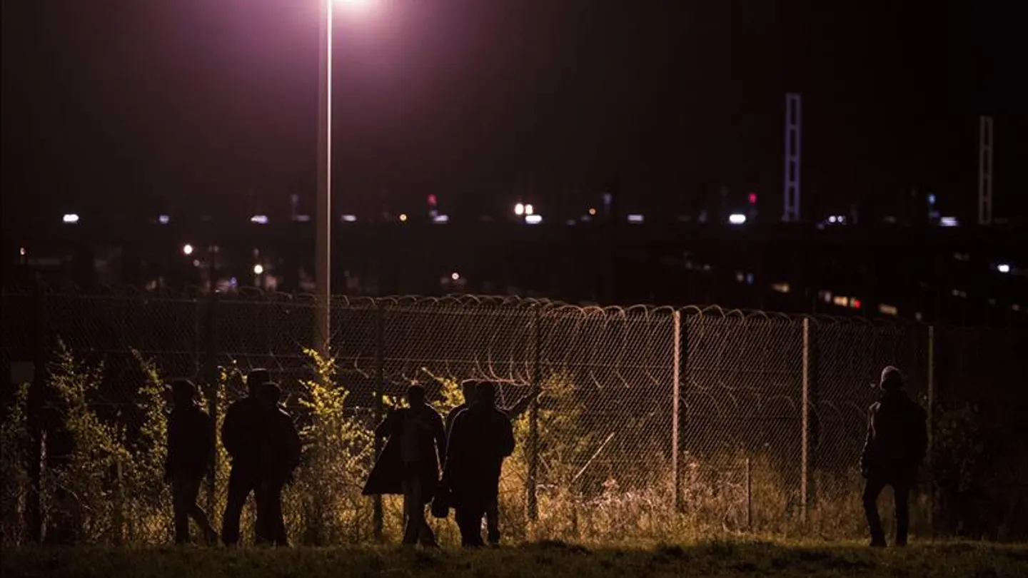Migrantes esperan un tren para ir a Inglaterra en Calais Migrantes esperan un tren para ir a Inglaterra en Calais