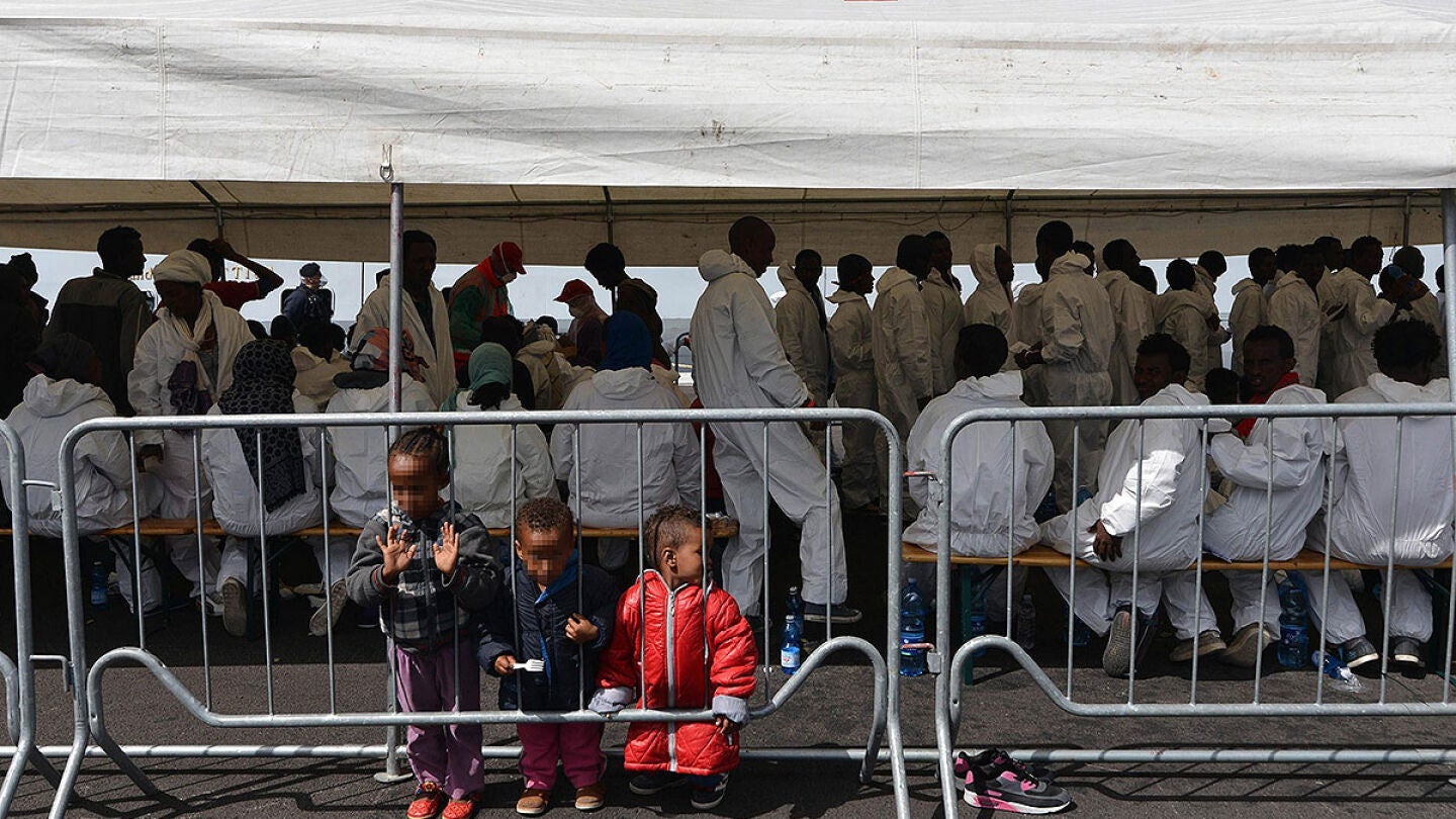 Inmigrantes bajo una carpa de Cruz Roja tras llegar a Salerno, Italia