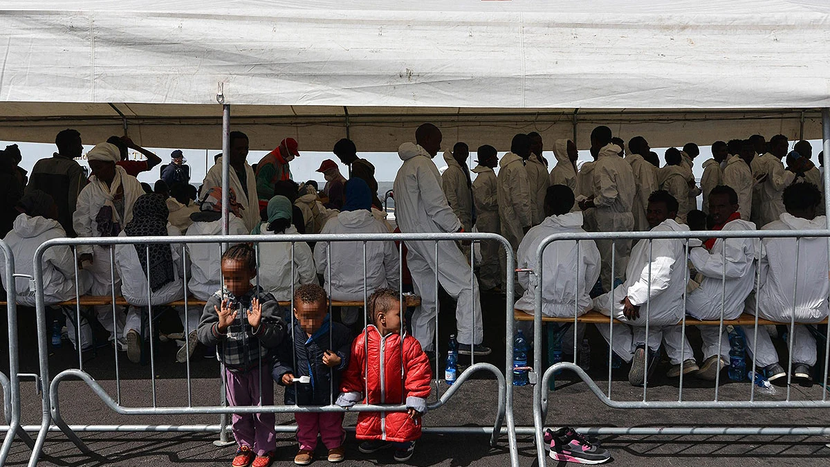 Inmigrantes bajo una carpa de Cruz Roja tras llegar a Salerno, Italia