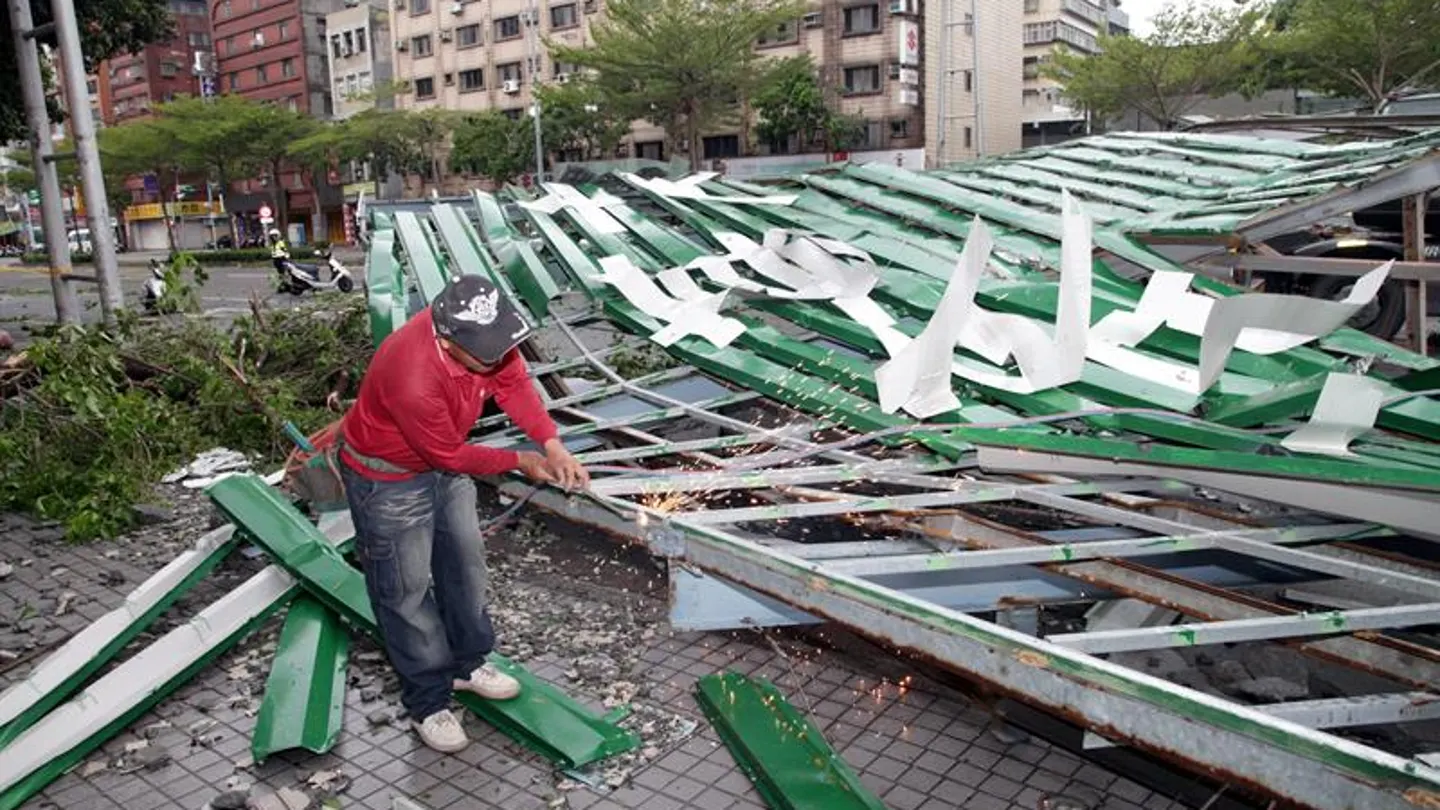 Un trabajador taiwanés corta una estructura derribada por el tifón Soudelor Un trabajador taiwanés corta una estructura derribada por el tifón Soudelor