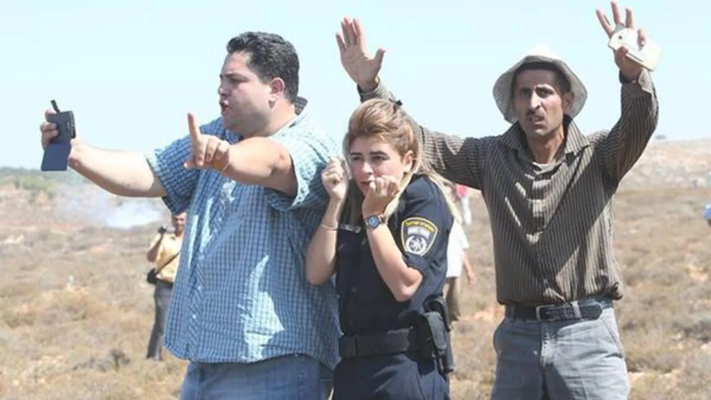 Dos palestinos protegen a una policía israelí de un ataque con piedras Dos palestinos protegen a una policía israelí de un ataque con piedras