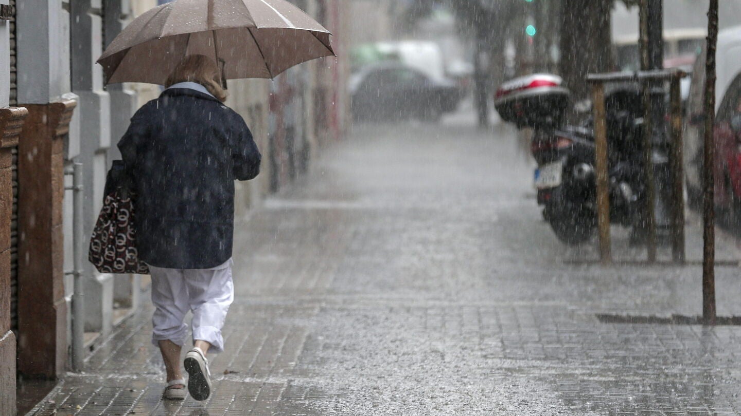 Una se&ntilde;ora se refugia de la lluvia