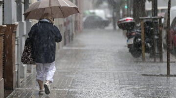 Una señora se refugia de la lluvia