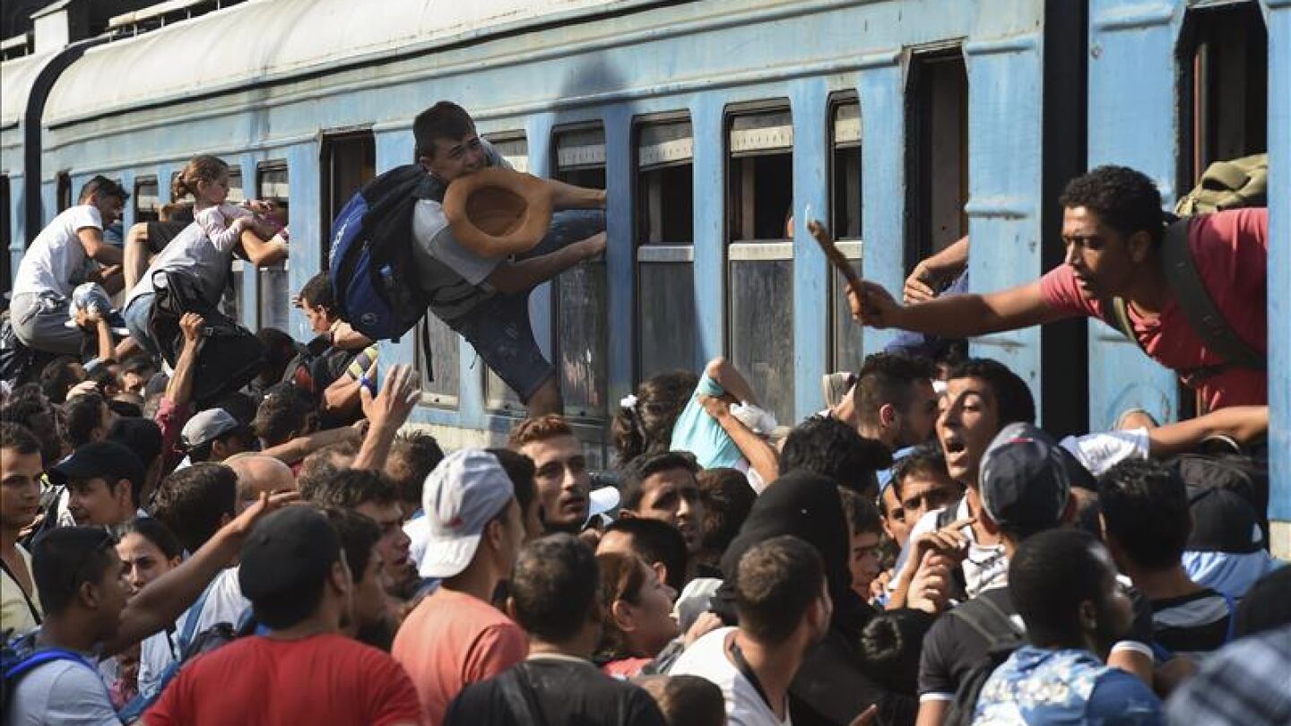 Refugiados sirios intentando subir al tren