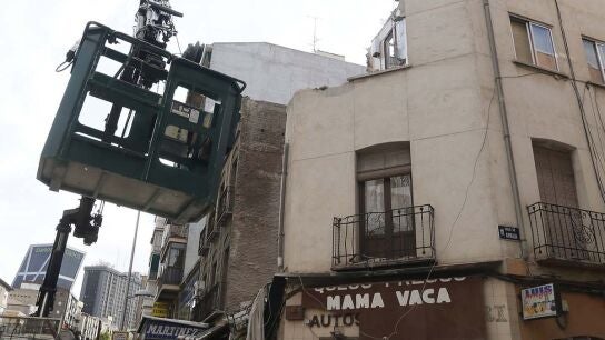 Una gr&uacute;a junto al edificio semiderruido