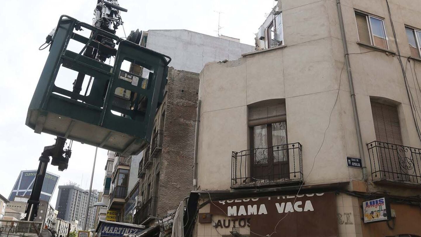 Una gr&uacute;a junto al edificio semiderruido