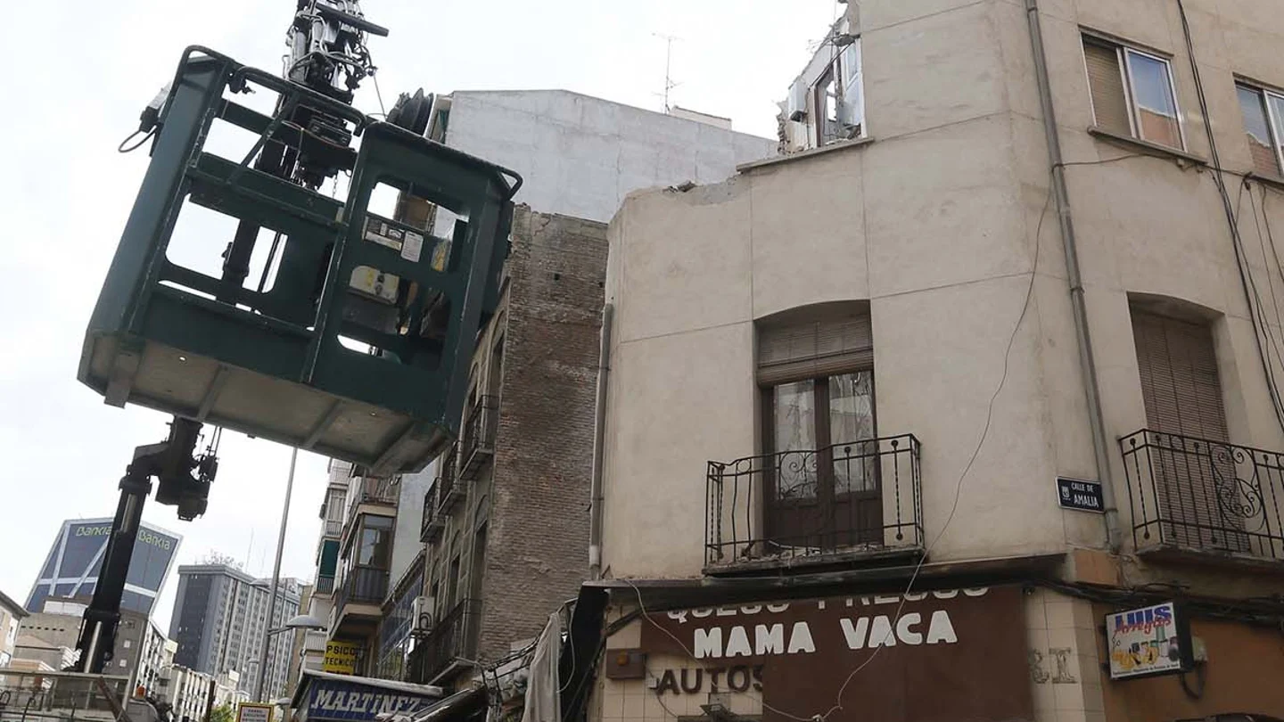 Una grúa junto al edificio semiderruido Una grúa junto al edificio semiderruido