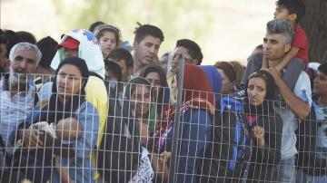 Inmigrantes esperan en el paso fronterizo de Macedonia y Grecia cerca de Gevgelija