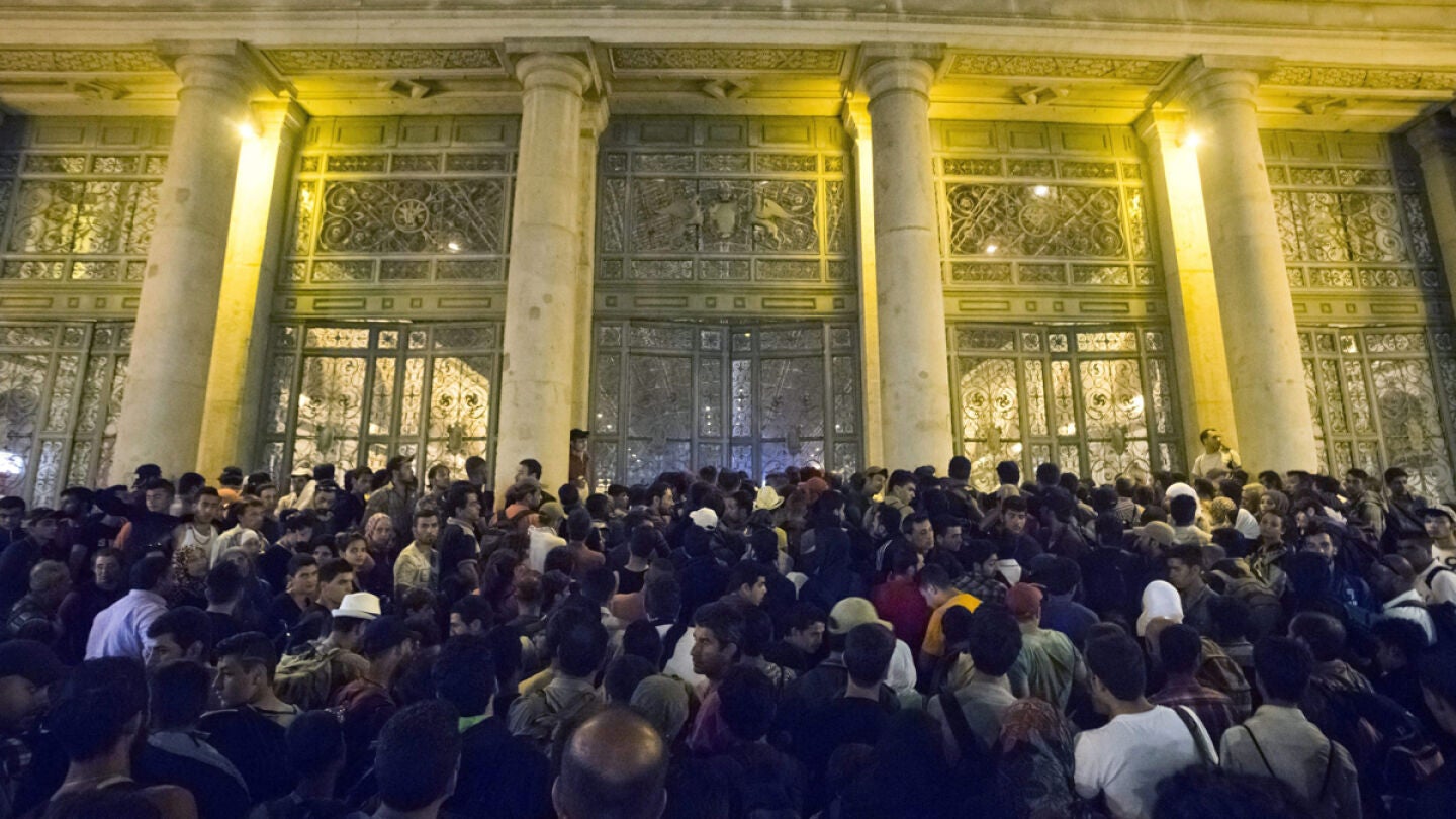 Inmigrantes esperan para subir al tren que les llevar&aacute; a Alemania