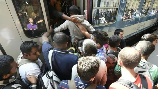 Inmigrantes subiendo a un tren en Hungría Inmigrantes subiendo a un tren en Hungría