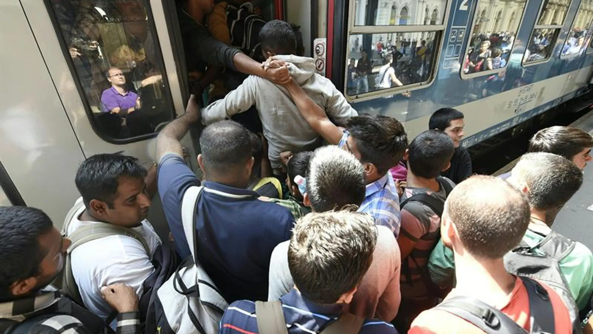 Inmigrantes subiendo a un tren en Hungría