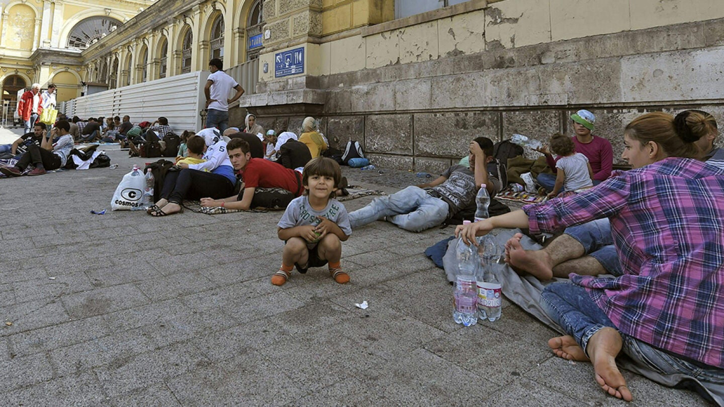 Inmigrantes descansan en el exterior de la estaci&oacute;n Keleti de Budapest