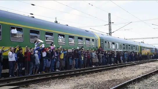 Refugiados aguardan al reparto de alimentos junto al tren Refugiados aguardan al reparto de alimentos junto al tren