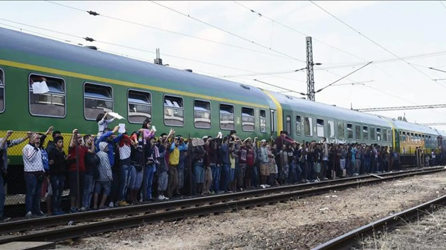 Refugiados aguardan al reparto de alimentos junto al tren Refugiados aguardan al reparto de alimentos junto al tren