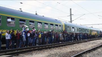 Refugiados aguardan al reparto de alimentos junto al tren