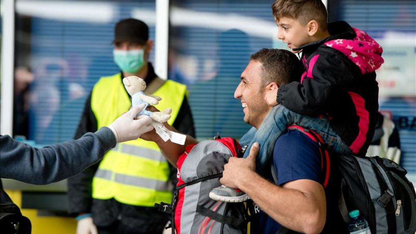 Un refugiado recibe un juguete tras llegar en tren a M&uacute;nich