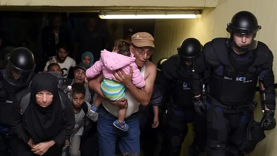 Varios inmigrantes, acompañados por policías, Varios inmigrantes, acompañados por policías,