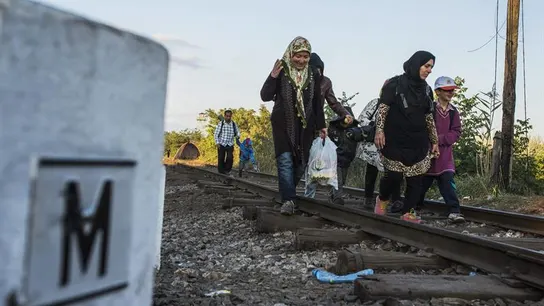 Migrantes procedentes de Serbia caminan por la vía del tren Migrantes procedentes de Serbia caminan por la vía del tren