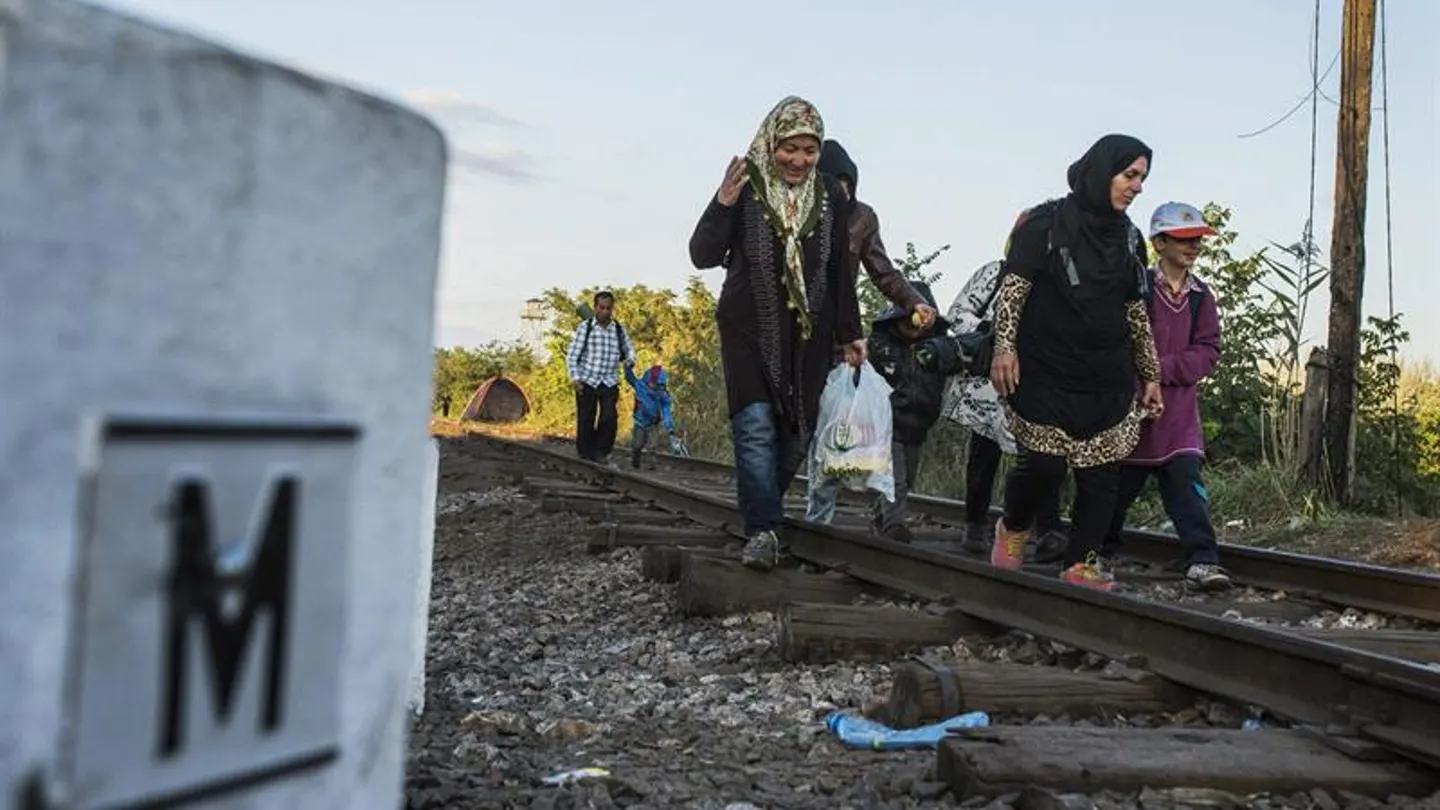 Migrantes procedentes de Serbia caminan por la vía del tren Migrantes procedentes de Serbia caminan por la vía del tren